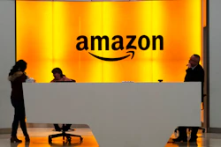 In this Feb. 14, 2019, file photo people stand in the lobby for Amazon offices in New York. Amazon says President Donald Trump's “improper pressure' and behind-the-scenes attacks harmed its chances of winning a $10 billion Pentagon contract. Amazon argues in a lawsuit unsealed Monday, Dec. 9, that the decision should be revisited because of “substantial and pervasive errors' and Trump's interference.