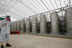 In this Nov. 12, 2014, file photo, a Tokyo Electric Power Co. (TEPCO) official wearing a radioactive protective gear stands in front of Advanced Liquid Processing Systems during a press tour at the Fukushima Dai-ichi nuclear power plant in Okuma, Fukushima Prefecture, northeastern Japan. Japan's economy and industry ministry has proposed gradually releasing or allowing to evaporate massive amounts of treated but still radioactive water at the tsunami-wrecked Fukushima nuclear plant. The proposal made Monday, Dec. 23, 2019, to a body of experts is the first time the ministry has narrowed down the options available to just releasing the water.