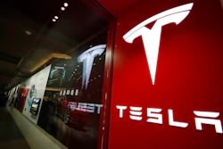 In this Saturday, Feb. 9, 2019, file photograph, a sign bearing the company logo stands outside a Tesla store in Cherry Creek Mall in Denver. Federal investigators have found that a 2018 crash and fire in Florida that killed the teenage driver of a Tesla Model S and a passenger was due to the car traveling at over 100 miles per hour on a curve. The National Transportation Safety Board says in a report released Thursday, Dec. 19, 2019 that the battery-powered car erupted in flames after colliding with a wall. The two 18-year-olds were trapped in the car.