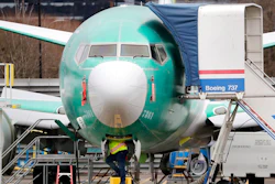 In this Dec. 16, 2019, file photo a worker looks up underneath a Boeing 737 MAX jet in Renton, Wash. Boeing doesn't expect federal regulators to approve its changes to the grounded 737 Max until this summer, according to two people familiar with the matter.