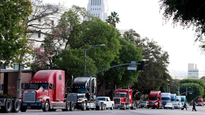 A caravan of trucks from the ports of Los Angeles and Long Beach drive around Los Angeles City Hall.