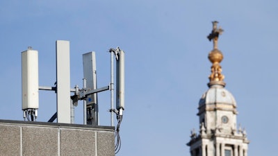 Mobile network phone masts are visible in front of St Paul's Cathedral in the City of London, Tuesday, Jan. 28, 2020.The Chinese tech firm Huawei has been designated a 'high-risk vendor' but will be given the opportunity to build non-core elements of Britain's 5G network, the government has announced. The company will be banned from the 'core', of the 5G network, and from operating at sensitive sites such as nuclear and military facilities, and its share of the market will be capped at 35%.