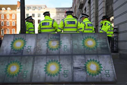 Police officers stand near activists outside BP's headquarters to mark the first day of the oil company's new chief executive Bernard Looney, at St James' Square in London, Wednesday Feb. 5, 2020.