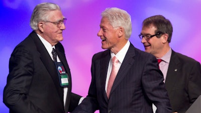 In this March 1, 2012 file photo, former President Bill Clinton shakes hands with Owen Bieber, left, with United Auto Workers union (UAW), at the 2012 UAW National Community†Action Program Conference, at the Marriott Wardman Park Hotel, in Washington.