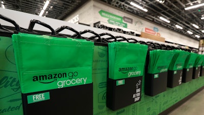 In this Feb. 21, 2020 photo, reusable shopping bags are displayed inside an Amazon Go Grocery store set to open soon in Seattle's Capitol Hill neighborhood.