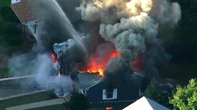 In this Sept. 13, 2018 file image from video provided by WCVB in Boston, flames consume the roof of a home following an explosion in Lawrence, Mass.