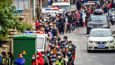 In this Jan. 29 file photo, people line up to buy face masks from a medical supply company in Nanning in southern China's Guangxi Zhuang Autonomous Region. Fear of the spreading coronavirus has led to a global run on sales of face masks despite medical experts' advice that most people who aren't sick don't need to wear them.