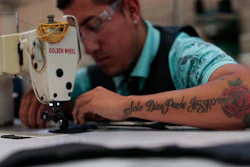 In this Feb. 13, 2020 photo, an employee, donning a tattoo with a motto reads in Spanish: 'Only God can judge me,' stitches shoe components at the Tenis Court factory, in Leon, Guanajuato state, Mexico. Part of Guanajuato’s odd reality stems from its success at cracking down on crimes that impact businesses together with its inability to stop the drug gang war.