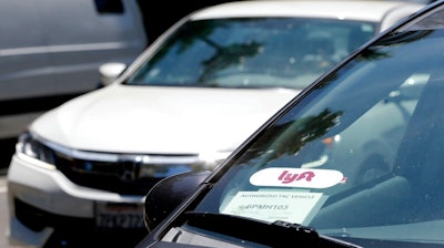 In this July 9, 2019, file photo a Lyft ride-share car waits at a stoplight in Sacramento, Calif. Ride-hailing service Lyft's annual loss more than doubled last year to over $2.6 billion, but the company claimed progress as revenue jumped 68% and ridership grew.
