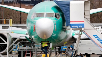 In this Dec. 16, 2019, file photo a worker looks up underneath a Boeing 737 MAX jet in Renton, Wash. Boeing sold no new airline jets in January, and now the company is worried that the virus outbreak in China could hurt airplane deliveries in the first quarter.