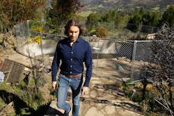 In this Tuesday, Feb. 25, 2020, photo, Jason Meek, whose Northern California wine country home was destroyed in 2017, walks through the remains of his home in Santa Rosa, Calif.