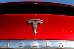 In this Feb. 2, 2020 file photograph, the company logo sits on an unsold 2020 Model X at a Tesla dealership in Littleton, Colo. Shares of Tesla Inc. fell 4% in early trading Thursday, Feb. 13, after the electric vehicle and solar panel maker said it would sell more than $2 billion worth of additional shares. The move comes just two weeks after CEO Elon Musk said the company had enough cash to fund its capital programs and it didn't need to raise any more money.