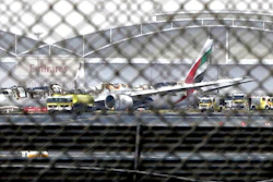 In this Aug 3, 2016 file photo, a damaged Boeing 777 is seen at the Dubai airport after it crash-landed, in Dubai, United Arab Emirates. An investigative report released Thursday, Feb. 6, 2020, found that the pilots of an Emirates flight that crashed in 2016 and caught fire in Dubai failed to realize the engines of their Boeing 777 remained idle as they tried to take off from a failed landing attempt.