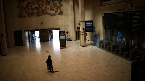 A man looks at train departures boards in a nearly empty Central station in Brussels, Wednesday, March 18, 2020.