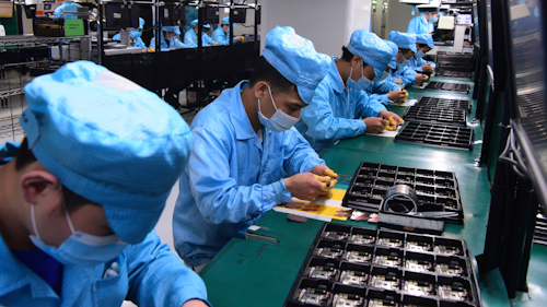 In this Feb. 13, 2020, photo released by Xinhua News Agency, workers wearing masks labor at a factory for Chinese telecommunications company OPPO.