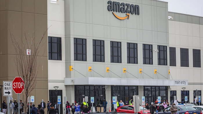 In this March 30, 2020 file photo, workers at Amazon's fulfillment center in Staten Island, N.Y., gather outside to protest work conditions in the company's warehouse in New York.