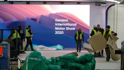 Workers dismantle a booth after that the 90th Geneva International Motor Show (GIMS) is cancelled by Swiss authorities, at the Palexpo in Geneva, Switzerland on Friday, Feb. 28. The 90th edition of the International Motor Show, scheduled to begin on March 5th, is cancelled due to the advancement of the (Covid-19) coronavirus in Switzerland. The Swiss confederation announced today that all events involving more than 1,000 people would be banned until 15 March.