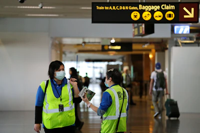 A pair of workers at Seattle-Tacoma International Airport wear masks on Tuesday, March 3 in SeaTac, WA. Six of the 18 Western Washington residents with the coronavirus have died as health officials rush to test more suspected cases and communities brace for spread of the disease. All confirmed cases of the virus in Washington are in Snohomish and King counties.