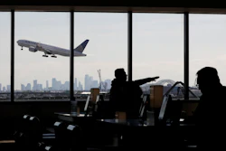 In this July 18, 2018, file photo, a United Airlines commercial jet takes off as travelers sit at a gate in Terminal C of Newark Liberty International Airport in Newark, N.J.