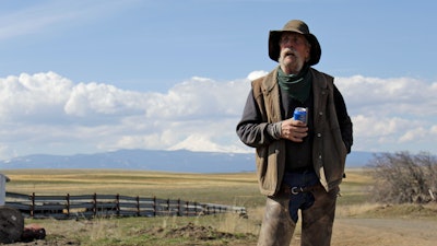 Cattle rancher Mike Filbin stands on his property in Dufur, Ore., after herding some cows and talks about the impact the new coronavirus is having on his rural community.