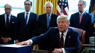 President Donald Trump speaks before he signs the coronavirus stimulus relief package in the Oval Office at the White House on Friday, March 27 in Washington.