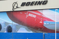 A worker walks near a mural of a Boeing 747-8 airplane at the company's manufacturing facility in Everett, Wash., Monday, March 23, 2020, north of Seattle. Boeing announced Monday that it will be suspending operations and production at its Seattle area facilities due to the spread of the new coronavirus.
