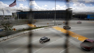 A few cars head south to cross from San Diego into Tijuana, Mexico, through what is normally one of the world's busiest land border crossings, Thursday, March 19, 2020, in San Diego.