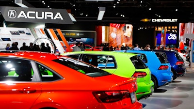 In a Jan. 15, 2019 file photo, signage for automakers Volkswagen, Acura, Chevrolet and Ford, at the North American International Auto Show in Detroit. The North American International Auto Show said that it will cancel its Detroit show because of the coronavirus pandemic.