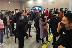 Travelers wearing masks line up to buy train tickets at a railway station in Yichang in central China's Hubei province Wednesday, March 25, 2020. Trains carrying factory employees back to work after two months in locked-down cities rolled out of Hubei province, the center of China's virus outbreak, as the government on Wednesday began lifting the last of the controls that confined tens of millions of people to their homes.