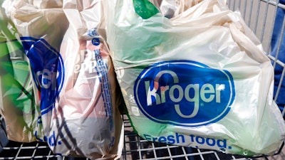 In this June 15, 2017, file photo, bagged purchases from the Kroger grocery store in Flowood, Miss., sit inside this shopping cart. A group of Instacart workers are organizing a strike across the U.S. starting Monday, March 30, 2020, to demand more pay and protection as they struggle to meet a surge in demand for grocery deliveries during the coronavirus pandemic.