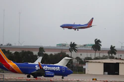 In this Jan. 10, 2020 file photo, a commercial plane flies into a windy, cloudy sky at the Fort Lauderdale-Hollywood International Airport in Fort Lauderdale, Fla. Federal regulators are temporarily waiving a rule that has been causing airlines to fly nearly empty planes to avoid losing precious takeoff and landing rights at major airports. On Wednesday, March 11, the FAA said it was waiving the 80% rule through May 31 to help airlines that are canceling flights because of the coronavirus outbreak.