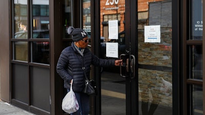 Visitors are unable to gain access to the Department of Labor due to closures over coronavirus concerns, Wednesday, March 18, 2020, in New York. Applications for jobless benefits are surging in some states as coronavirus concerns shake the U.S. economy. The sharp increase comes as governments have ordered millions of workers, students and shoppers to stay home as a precaution against spreading the virus that causes the COVID-19 disease.