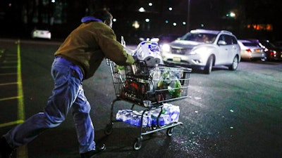 Customer Harry Westhoff, 71, runs his groceries back to his car after shopping at a Stop & Shop supermarket that opened special morning hours to serve people 60-years and older due to coronavirus concerns, Friday, March 20, 2020, in Teaneck, N.J. For most people, COVID-19, the disease caused by the new coronavirus, causes only mild or moderate symptoms, such as fever and cough. For some, especially older adults and people with existing health problems, it can cause more severe illness, including pneumonia.