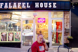Clade Karim takes a take out order over the phone for Falafel House in downtown Grandin on Monday night, March 30, 2020.