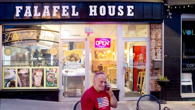 Clade Karim takes a take out order over the phone for Falafel House in downtown Grandin on Monday night, March 30, 2020.