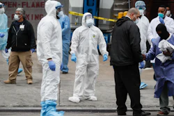 Medical workers wearing personal protective equipment due to COVID-19 concerns pause for rest before loading bodies onto a refrigerated container truck functioning as a makeshift morgue, Tuesday, March 31, 2020, at Brooklyn Hospital Center in Brooklyn borough of New York.