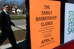 A pedestrian walks by The Family Barbershop, closed due to a Gov. Gretchen Whitmer executive order, in Grosse Pointe Woods, Mich., Thursday, April 2, 2020.
