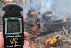 A Geiger counter shows increased radiation level against the background of the forest fire burning near the village of Volodymyrivka in the exclusion zone around the Chernobyl nuclear power plant, Ukraine, Sunday, April 5, 2020.