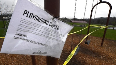A sign announces another playground closed due to coronavirus concerns as caution tape is wrapped around the swings at Ohio Township Community Park, Tuesday, April 7, 2020, in Ohio Township, Pa.
