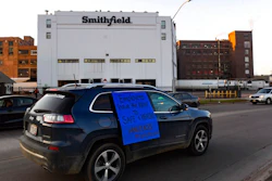 In this Thursday, April 9, 2020 photo, a car sporting a sign calling for a safe and healthy workplace drives past Smithfield Foods, Inc. in Sioux Falls. during a protest on behalf of employees after many workers complained of unsafe working conditions due to the COVID-19 outbreak.