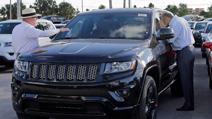 In this Thursday, Nov. 5, 2015, file photo, salesperson Andrew Montalvo, left, talks to a customer checking out the interior of a 2015 Grand Cherokee Limited in Doral, Fla. Fiat Chrysler is betting the SUV craze is here to stay and drivers around the world will want even more Jeeps. The company said Wednesday, Jan. 27, 2016, it predicts Jeep brand sales will nearly double to 2 million worldwide by 2018. (AP Photo/Alan Diaz, File)