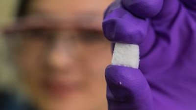 Rice University postdoctoral researcher Pei Dong holds a sample of SAC, a new form of self-adapting composite. The material has the ability to heal itself and to regain its original shape after extraordinary compression.