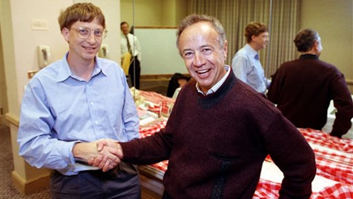 In this Nov. 9, 1992, file photo, Intel Corp. President Andy Grove, right, shakes hands with Microsoft Chairman Bill Gates at a meeting in Burlingame, Calif.