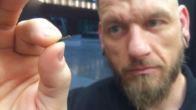 Self-described “body hacker” Jowan Osterlund from Biohax Sweden, holds a small microchip implant, similar to those implanted into workers at the Epicenter digital innovation business centre during a party at the co-working space in central Stockholm, Tuesday March 14, 2017. Microchips are being implanted into volunteers to help them open doors and operate office equipment, and its become so popular that members of the Epicentre cyborg club hold regular parties for those with the tiny chips embedded in their hands.
