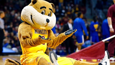 In this Nov. 13, 2015 file photo, Minnesota mascot Goldy Gopher gestures to the crowd during the first half of an NCAA college basketball game against UMKC in Minneapolis. The university is among several that aggressively protects it's trademark. It ordered a British liquor company to rename its Goldy Gin brand and abandon its trademark applications for the name, saying that consumers would think its products were licensed by the university.