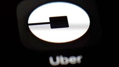 This March 20, 2018, file photo shows the Uber app on an iPad in Baltimore. Uber may put forth an initial public offering early next year that values the ride-hailing business at as much as $120 billion, according to a media report. The Wall Street Journal said Tuesday, Oct. 16, that Uber Technologies Inc. received valuation proposals from Goldman Sachs and Morgan Stanley.