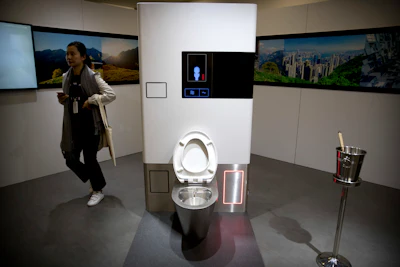 A visitor looks at a display at the Reinvented Toilet Expo in Beijing, Tuesday, Nov. 6, 2018. With a jar of human feces on a podium next to him, billionaire philanthropist Bill Gates has kicked off a 'Reinvented Toilet' Expo in China. Gates said Tuesday that the technologies on display at the three-day expo in Beijing represent the most significant advances in sanitation in nearly 200 years.