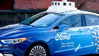 In this Dec. 18, 2018, photo, one of the test vehicles from Argo AI, Ford's autonomous vehicle unit, navigates through the strip district near the company offices in Pittsburgh. The people developing self-driving vehicles say it could be anywhere from 10 years to decades before the cars will be carrying passengers in every city. Researchers are trying to conquer a number of obstacles.
