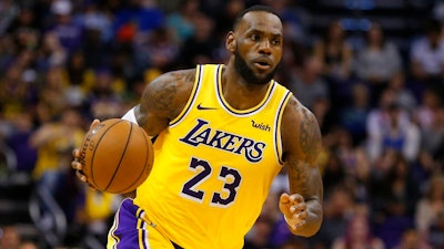 In this Saturday, March 2, 2019, file photo, Los Angeles Lakers forward LeBron James (23) controls the ball in the second half during an NBA basketball game against the Phoenix Suns in Phoenix. That LeBron James jersey could get a little more expensive. Companies that make clothing and shoes for the National Basketball Association players are in the crosshairs of President Donald Trump’s escalating China trade wars.