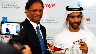 SpiceJet chairman and managing director Ajay Singh, left, and Sheikh Khalid bin Saud Al Qasimi, a son of Ras al-Khaimah ruler Sheikh Saud bin Saqr Al Qasimi, right, pose for photographs during a news conference in Ras al-Khaimah, United Arab Emirates, Wednesday, Oct. 23, 2019. India's low-cost airline SpiceJet announced plans Wednesday to build its first international hub in the United Arab Emirates, offering a pledge of support to Boeing Co. by saying it would use now-grounded 737 MAX aircraft in the operation once regulators approve the planes for flight.